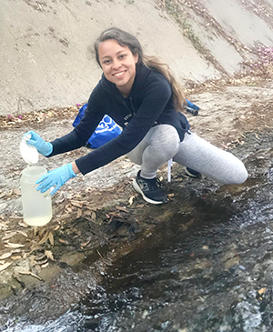 Ileana Callejas collecting water sample in Chautauqua Creek