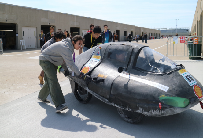 The Bruin Supermileage Vehicle team pushes their car