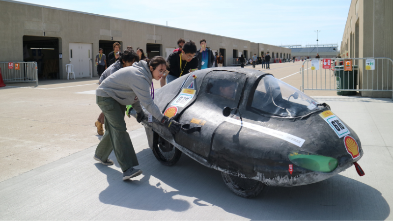 The Bruin Supermileage Vehicle team pushes their car