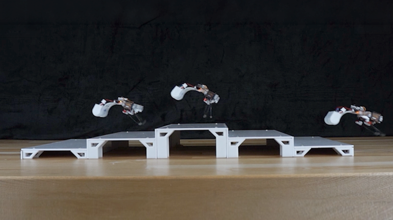The robot shown in mid-air, leaping up a set of small steps.